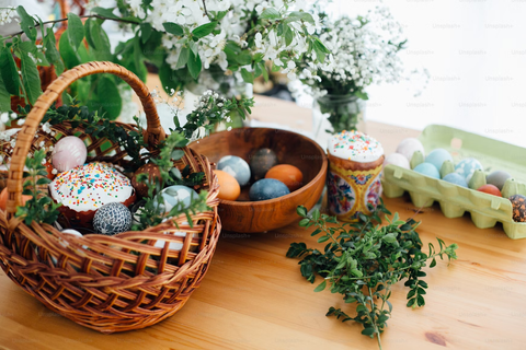 homemade easter basket with a variety of colored eggs and green foliage - Compartés